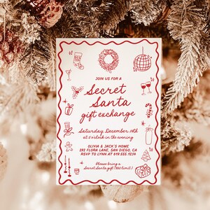May include: A white invitation card with a red scalloped border, featuring festive illustrations and the text "Secret Santa gift exchange." The card includes event details: date, time, location, and RSVP information. The background shows a Christmas tree with ornaments.