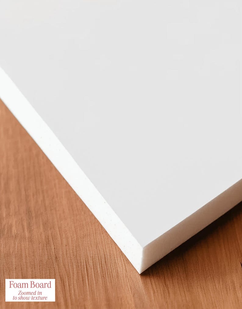 May include: A white foam board with a textured surface, shown at an angle. The board is on a wooden surface. The text "Foam Board" and "Zoomed in to show texture" is in the lower left corner.