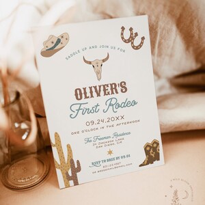 May include: A white invitation with brown and blue text for a rodeo themed party. The invitation says "Oliver's First Rodeo" with the date "09.24.20XX" and the time "One o'clock in the afternoon". The invitation also includes a cowboy hat, a skull, a horseshoe, a cactus, and cowboy boots.