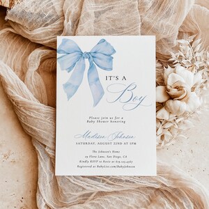 May include: A baby shower invitation with a blue watercolor bow and the text "It's a Boy". The invitation includes the name "Madison Johnson", the date "Saturday, August 22nd at 1 PM", the location "The Johnson's Home, 29 Flora Lane, San Diego, CA", and the RSVP information.