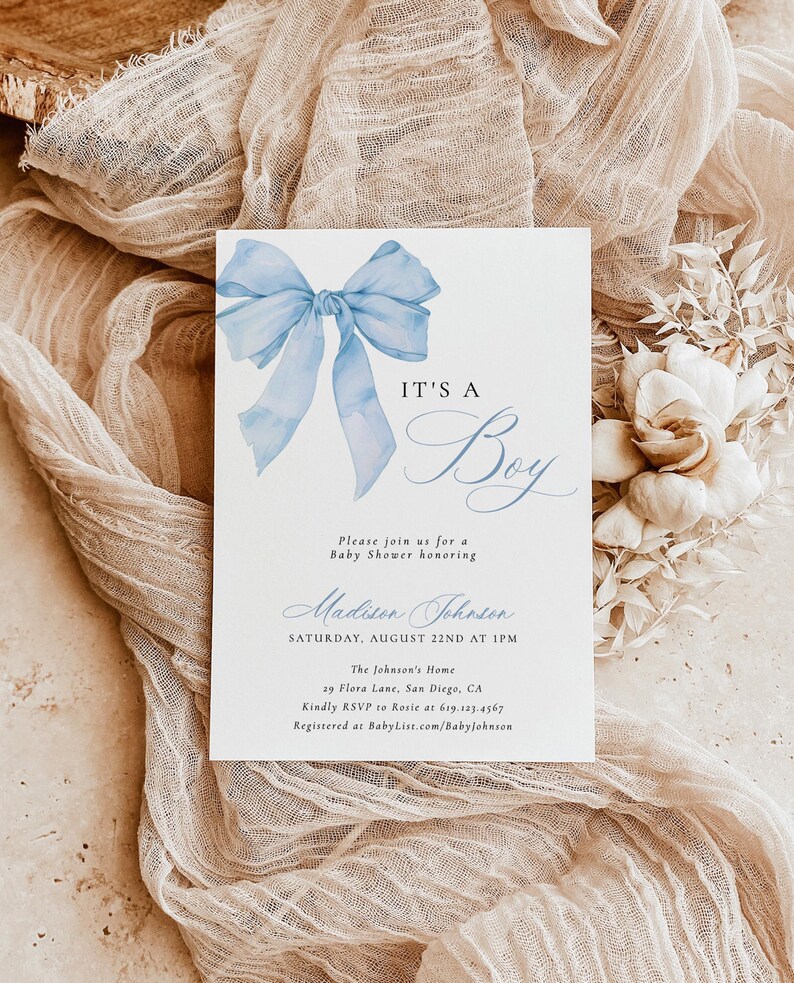 May include: A baby shower invitation with a blue watercolor bow and the text "It's a Boy". The invitation includes the name "Madison Johnson", the date "Saturday, August 22nd at 1 PM", the location "The Johnson's Home, 29 Flora Lane, San Diego, CA", and the RSVP information.