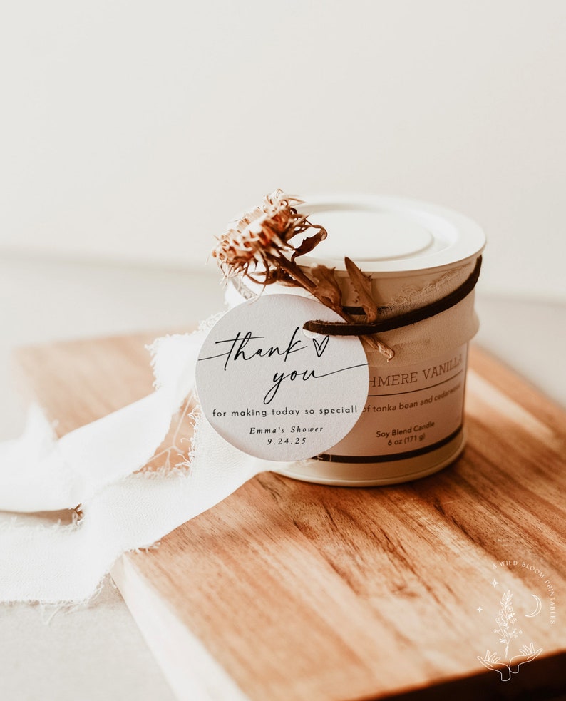 May include: A white candle jar with a brown ribbon and a white tag that says "Thank you for making today so special! Emma's Shower 9.24.25". The candle jar is labeled "Cashmere Vanilla Soy Blend Candle 6 oz (171 g)".