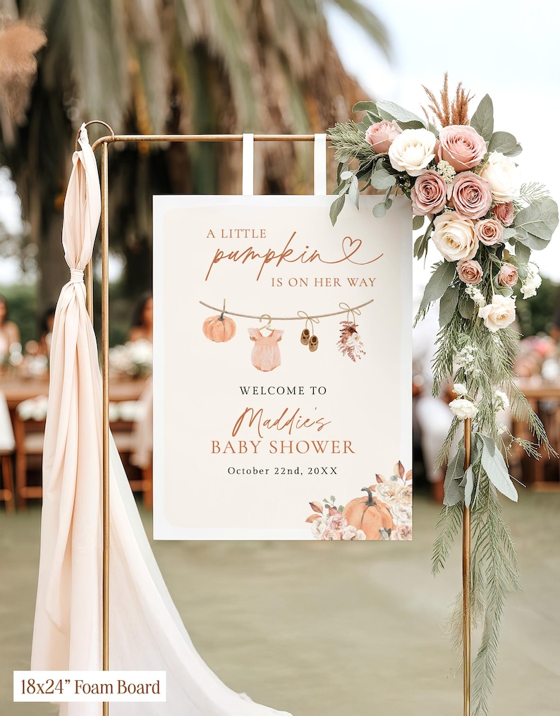 May include: A rectangular 18x24 inch foam board sign for a baby shower. The sign features the text A LITTLE pumpkin IS ON HER WAY, WELCOME TO Maddie's BABY SHOWER, and October 22nd, 20XX. Graphics include a clothesline with a pumpkin, onesie, and shoes.
