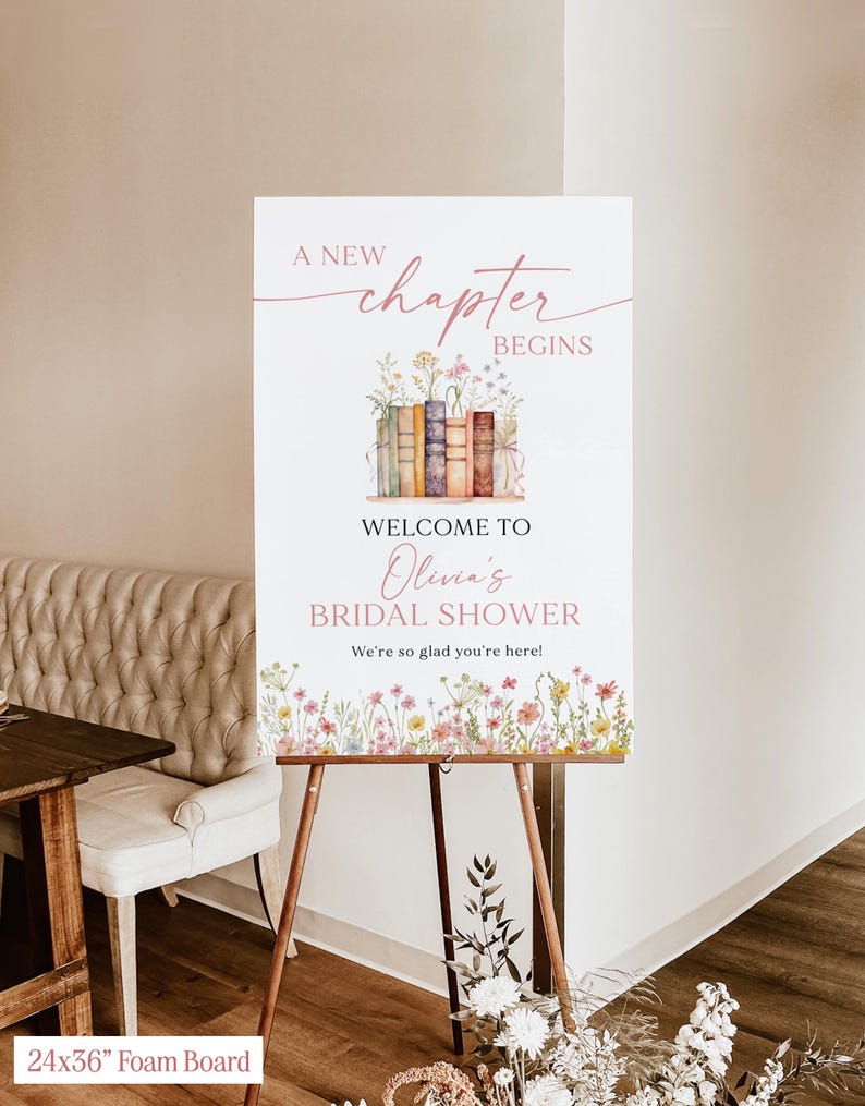 May include: A 24x36 inch foam board sign on a wooden easel. The sign reads "A New Chapter Begins" above "Welcome to Olivia's Bridal Shower." Floral and book illustrations decorate the sign, with the text "We're so glad you're here!"