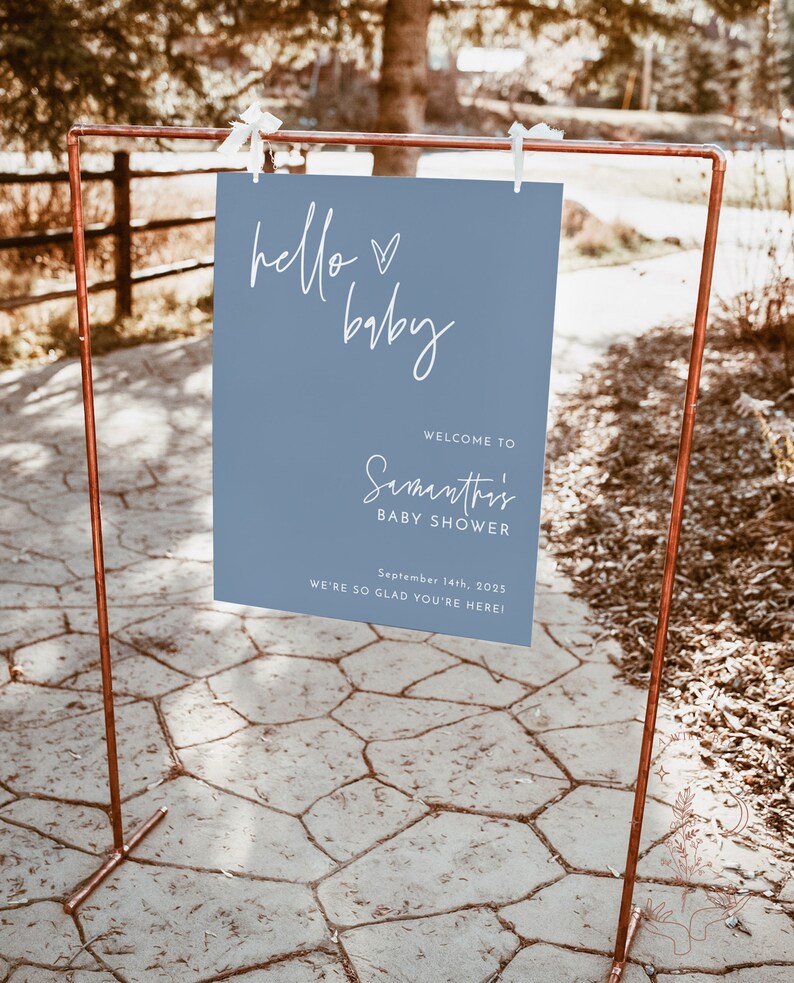 Może przedstawiać: Niebieski znak powitalny z białym tekstem, kt&oacute;ry brzmi "hello baby" i "Witamy na Baby Shower Samanthi 14 września 2025 Cieszymy się, że jesteś!"