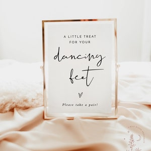 Op de afbeelding: Een gouden lijst met de tekst "A little treat for your dancing feet" en een hartje. Het bord zegt ook "Please take a pair!"