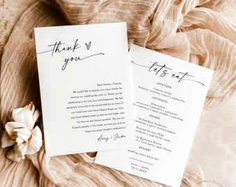 May include: Two white cards with black text. The first card says "Thank you" with a heart symbol. The second card says "Let's eat" and lists a wedding menu with appetizers, antipasto, entree, and dessert. The text on the cards is in a handwritten style.