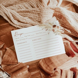 Pu&ograve; includere: Un biglietto da ricetta stampabile con un design floreale ad acquerello in tonalit&agrave; di marrone, beige e bianco. Il biglietto ha righe per scrivere il titolo della ricetta, le porzioni, il tempo di preparazione, il tempo totale, gli ingredienti e le istruzioni.