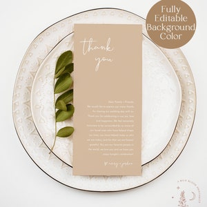 May include: A thank you card with a beige background and white text. The card says "thank you" in a script font and includes a message thanking family and friends for celebrating their wedding day. The card is sitting on a white plate with a decorative pattern.