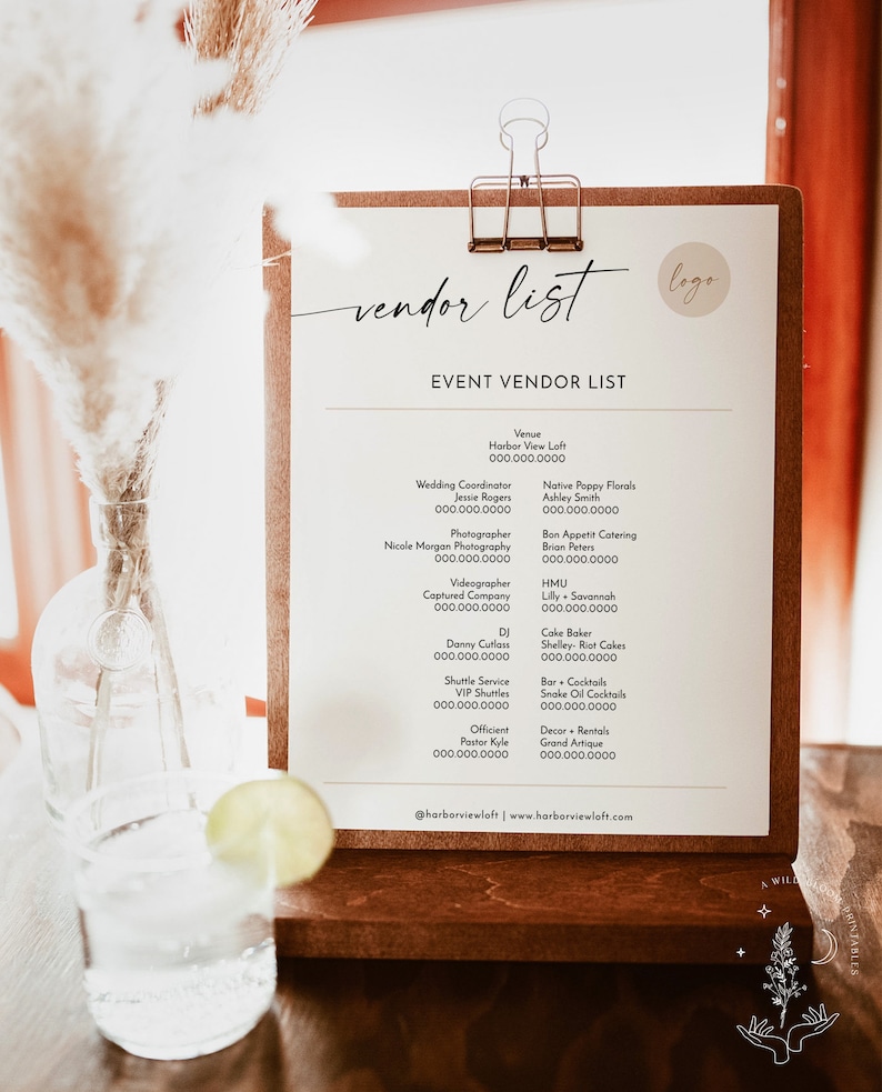 Pu&ograve; includere: Una clipboard bianca con una cornice in legno marrone e una clip dorata. La clipboard contiene un elenco di fornitori di matrimoni in bianco e nero. L'elenco include i nomi e le informazioni di contatto del luogo, del coordinatore di matrimoni, del fotografo, del videomaker, del DJ, del servizio navetta, dell'ufficiante, del fiorista, del catering, dell'artista di trucco e parrucco, del pasticcere, del bar e del noleggio di decorazioni.