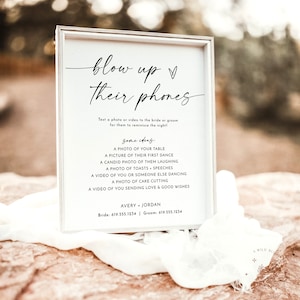 May include: A white sign with black text that reads "blow up their phones" and includes instructions for guests to text photos or videos to the bride and groom. The sign also includes a list of ideas for photos and videos, such as a photo of the table, a picture of their first dance, and a video of cake cutting. The sign also includes the bride and groom's names and phone numbers.