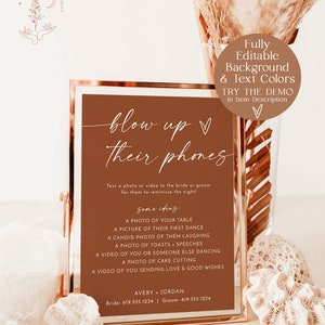 May include: A printable sign with a brown background and white text that says "blow up their phones". The sign is in a gold frame and has instructions for guests to text a photo or video to the bride and groom. The sign also includes some ideas for photos and videos, such as a photo of their first dance, a candid photo of them laughing, and a video of someone else dancing.