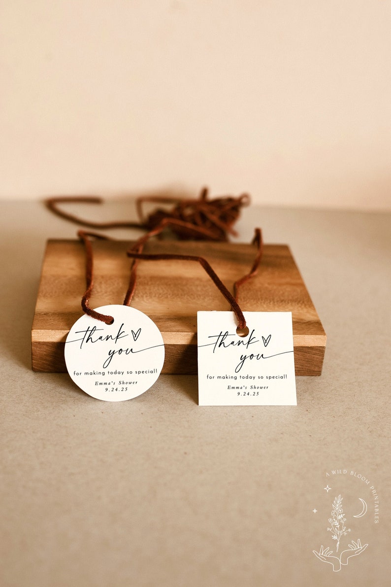 May include: Two white thank you tags with black calligraphy. The text reads "Thank you" with a heart symbol and "for making today so special!"  The tags also include the text "Emma's Shower" and the date "9.24.25".