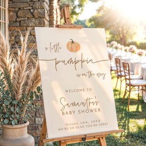 May include: A 24x36 inch foam board sign on a wooden easel featuring a watercolor pumpkin illustration and the text: A little pumpkin is on the way, WELCOME TO Samantha's BABY SHOWER, October 18th, 20XX, WE'RE SO GLAD YOU'RE HERE!
