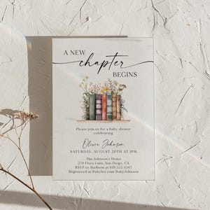 May include: Baby shower invitation with the text "A New Chapter Begins." The invitation features a watercolor illustration of books with flowers. The details include the date, time, and location.