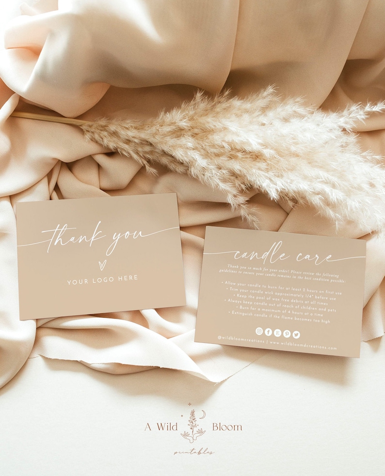 May include: Two beige cards with white text. The first card says "Thank you" with a heart symbol and "YOUR LOGO HERE". The second card says "candle care" and includes instructions for candle care. The cards are on a beige fabric background with a dried pampas grass sprig.