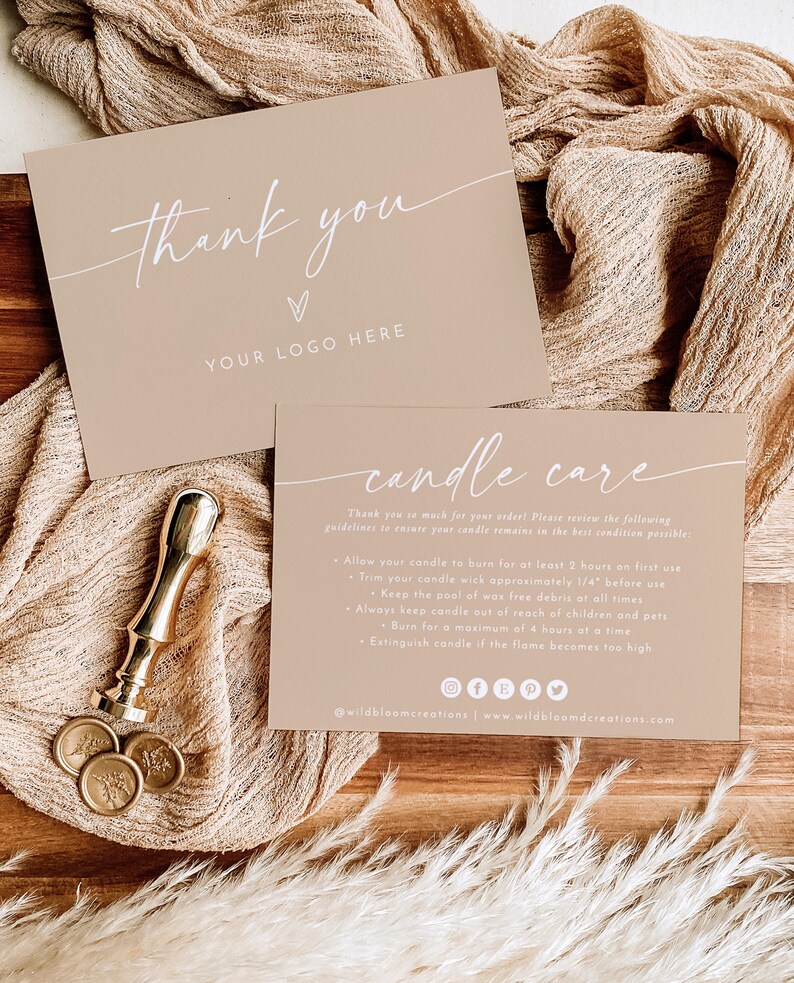 May include: A thank you card with a white heart and the text "YOUR LOGO HERE" in white. Below the card is a candle care card with instructions for burning candles, including burning for a maximum of 4 hours at a time. The text is in white on a beige background. The cards are on a wooden surface with a beige fabric.