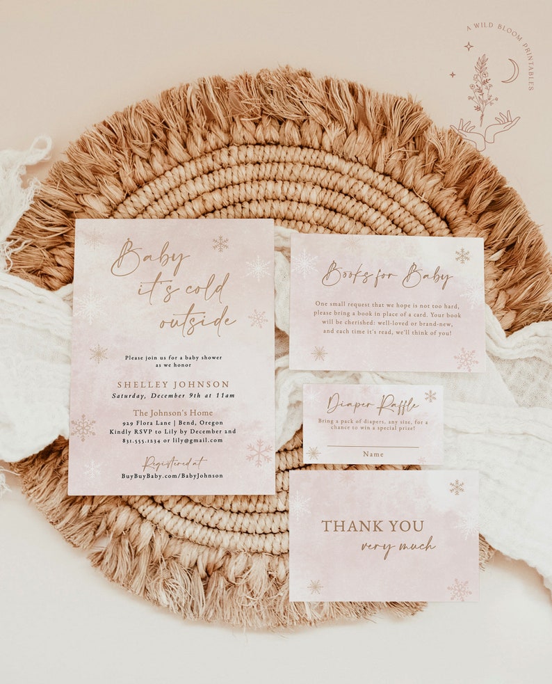 Op de afbeelding: Een setje baby shower briefpapier met een aquareleffect. De uitnodiging luidt "Baby it's cold outside" met sneeuwvlokdetails. Inclusief kaarten voor boeken, een luier verloting en bedankjes. Het ontwerp is in zachtroze en goud.