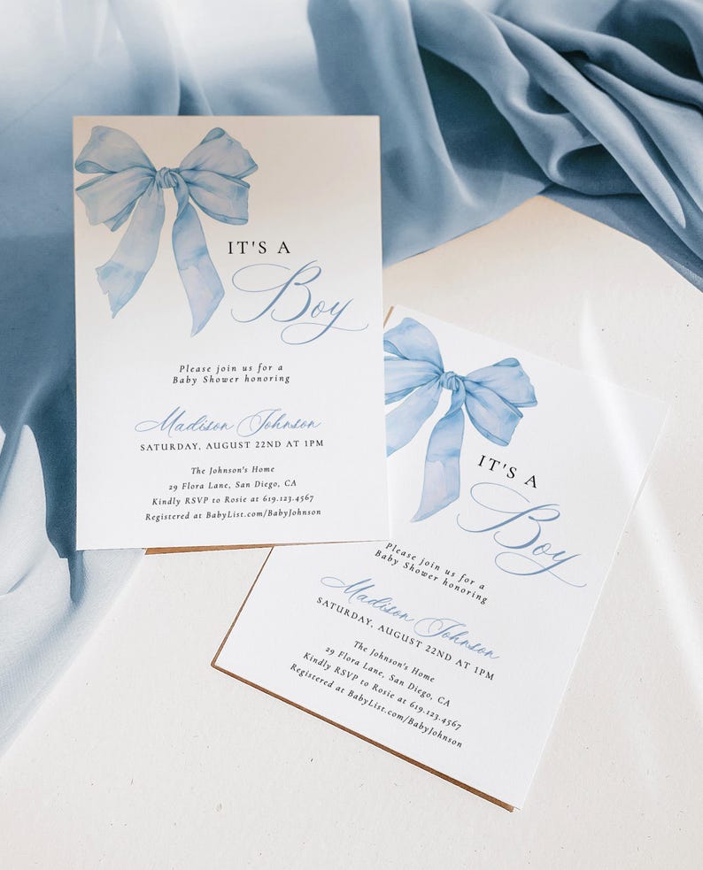 May include: Blue watercolor bow with the text "It's a Boy" on a white card with a brown border. The card is a baby shower invitation for Madison Johnson. The invitation includes the date, time, location, and RSVP information.
