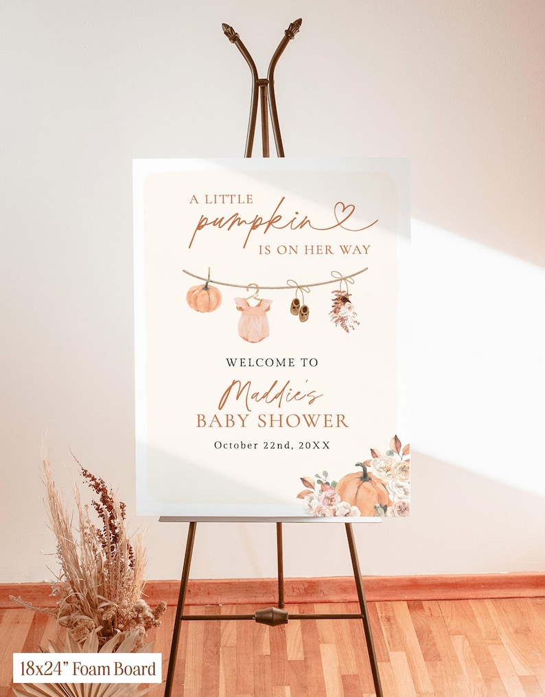 May include: A rectangular 18x24 inch foam board sign featuring the text A LITTLE pumpkin IS ON HER WAY, WELCOME TO Maddie's BABY SHOWER, and October 22nd, 20XX. The design includes illustrations of a pumpkin, baby clothes, and flowers.