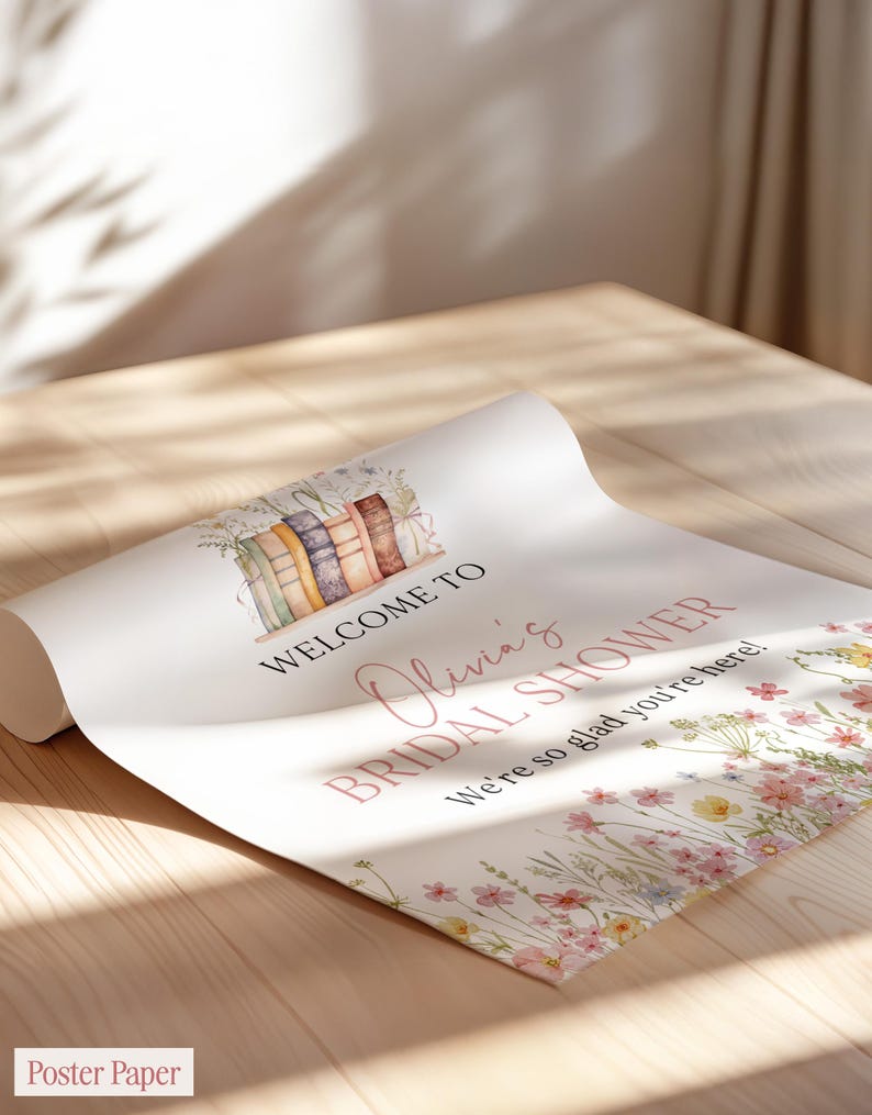 May include: A rolled-up poster with the text "Welcome to Olivia's Bridal Shower" in pink script. The poster features a watercolor illustration of books and wildflowers. The words "We're so glad you're here!" are also included.