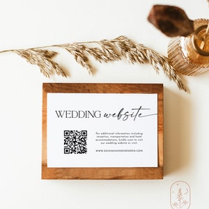 May include: A white card with the text "WEDDING website" in black script font. A black and white QR code is below the text. The text "For additional information including reception, transportation and hotel accommodations, kindly scan to visit our wedding website or visit: WWW.SAVANAHANDHENDRIX.COM" is below the QR code.