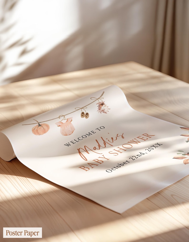 May include: A white poster paper sign featuring a watercolor illustration of a string with a pumpkin, baby clothes, and shoes. The text reads: WELCOME TO Maddies BABY SHOWER October 22nd, 20XX. The design includes autumn-themed foliage accents.