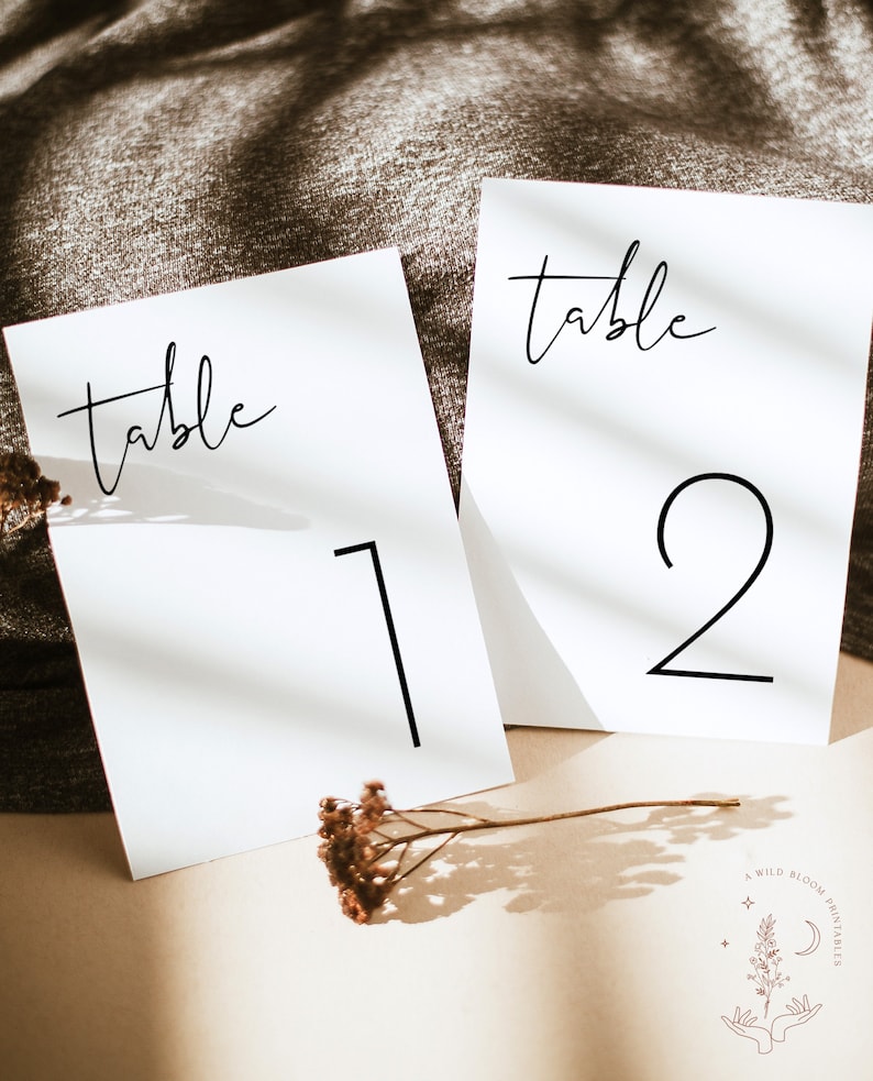 May include: Two white cards with black text. The top of each card says "table". The first card has the number "1" on it and the second card has the number "2" on it.