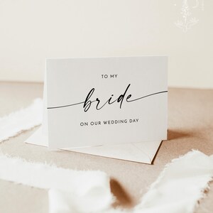 Op de afbeelding: Een witte kaart met zwarte tekst die "To my bride on our wedding day" zegt.