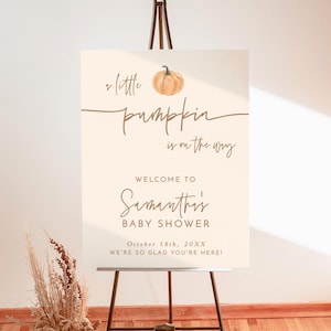 May include: A rectangular 18x24 inch foam board sign on a metal easel. The cream-colored sign features a watercolor pumpkin illustration and brown text reading: A little pumpkin is on the way, WELCOME TO Samantha's BABY SHOWER, October 18th, 20XX, WE'RE SO GLAD YOU'RE HERE!