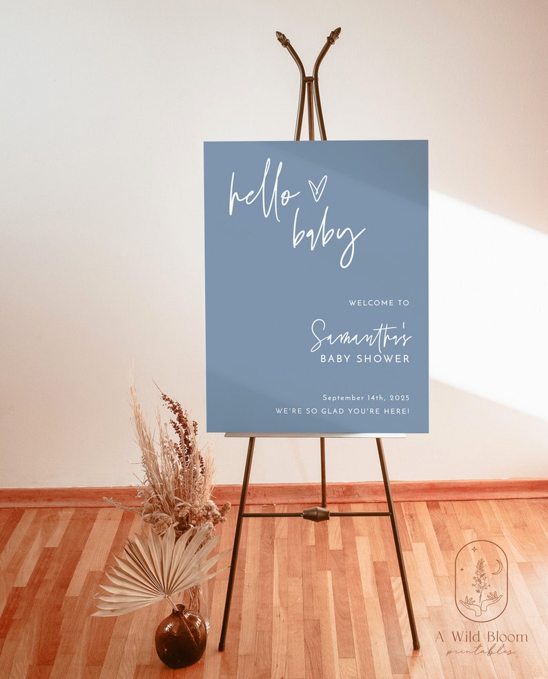Może przedstawiać: Niebieski napis powitalny z białym tekstem, kt&oacute;ry brzmi "hello baby" i "Witamy na Baby Shower Samanthi" z datą "14 września 2025" i tekstem "Cieszymy się, że jesteś!" Napis stoi na czarnym sztalugach.