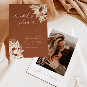 Może przedstawiać: Brązowa karta zaproszenia z białym wzorem kwiatowym i tekstem "bridal shower" w białym piśmie. Zaproszenie jest na wiecz&oacute;r panieński dla Hannah Peterson 26 sierpnia o 12:30 w Fig Tree Cafe w Santa Cruz, Kalifornia. Zaproszenie zawiera r&oacute;wnież tekst "future mrs. Sanders" w białym piśmie.