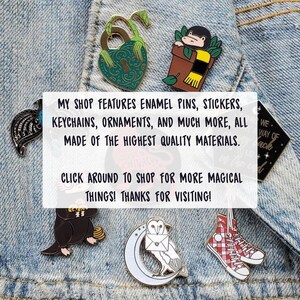 K&ouml;nnte beinhalten: Eine Sammlung von Emaille-Pins mit verschiedenen Designs, darunter ein herzf&ouml;rmiges Schl&uuml;sselloch, eine Topfpflanze mit einem Schal, eine schwarz-wei&szlig;e Eule, ein rot-wei&szlig; kariertes Schuh und eine schwarze Kreatur mit einem runden K&ouml;rper und kleinen Beinen. Die Pins sind auf einem blauen Jeansstoff-Hintergrund abgebildet. Der Text "MY SHOP FEATURES ENAMEL PINS, STICKERS, KEYCHAINS, ORNAMENTS, AND MUCH MORE, ALL MADE OF THE HIGHEST QUALITY MATERIALS. CLICK AROUND TO SHOP FOR MORE MAGICAL THINGS! THANKS FOR VISITING!" ist im Bild sichtbar.
