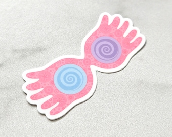 Puede incluir: Pegatina rosa y azul con estampado de un par de gafas con diseño de espiral. Las gafas tienen forma de ojos con una forma de mano a cada lado.