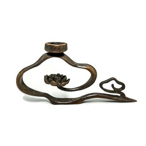 Peut inclure: Un brûle-encens en bronze en forme de nuage avec un motif de fleur de lotus. Le brûleur a une petite ouverture ronde sur le dessus pour les bâtonnets d'encens.