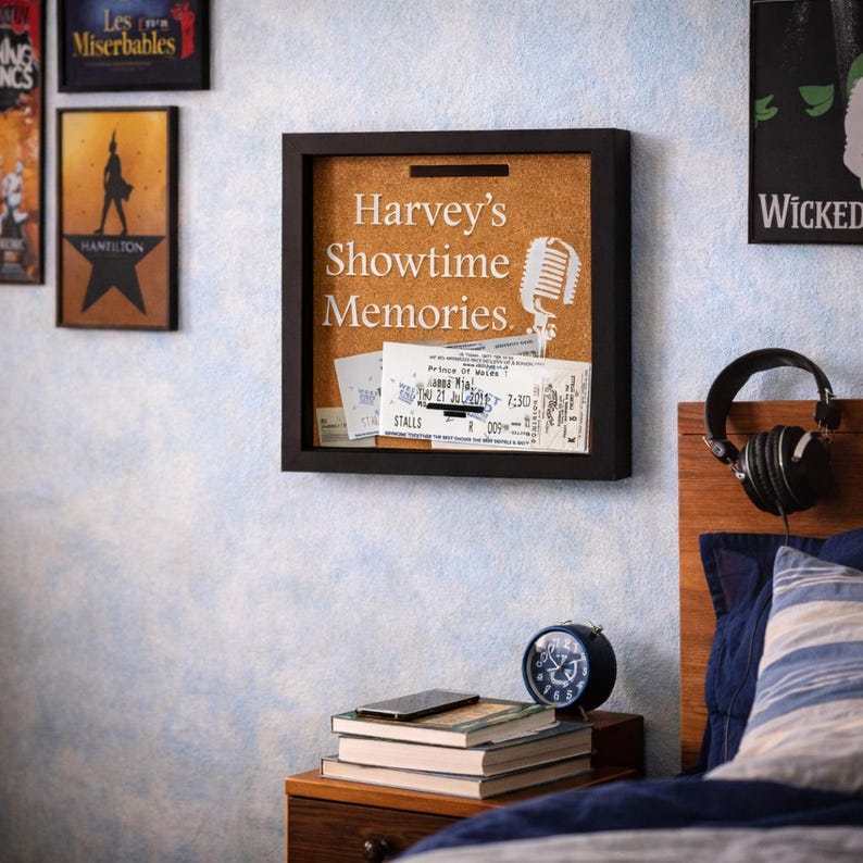 May include: A white ceramic mug with a black handle and the text "But First, Coffee" in a bold, black font. The mug is set against a blurred background, suggesting a cozy setting.