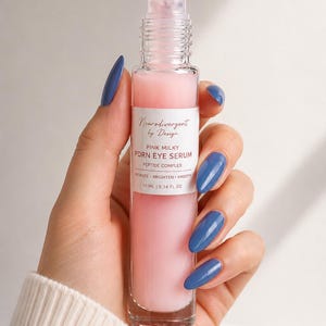 Peut inclure: Un flacon &agrave; bille en verre transparent contenant un s&eacute;rum pour les yeux rose laiteux. L'&eacute;tiquette blanche indique Neurodivergent by Design, PINK MILKY PDRN EYE SERUM, PEPTIDE COMPLEX, HYDRATE BRIGHTEN SMOOTH, et 10 ml | 0.34 fl oz. Bouchon transparent.