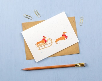 Dachshunds sledging in the snow- Christmas greetings card