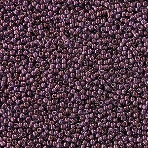 May include: A close-up view of a large quantity of small, round, metallic beads. The beads are a deep, rich purple color with a slight sheen.