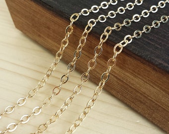 May include: Four different sizes of gold chain, displayed on a wooden surface. The chains are all made of the same material and have a smooth, polished finish.
