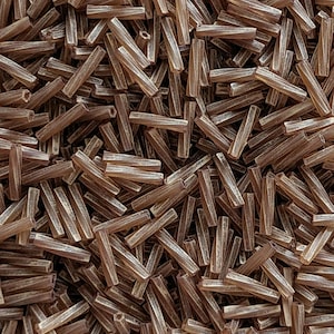 May include: A large pile of brown glass beads, each bead is a long, thin cylinder with a slightly rounded end. The beads have a subtle shimmer and are perfect for jewellery making.