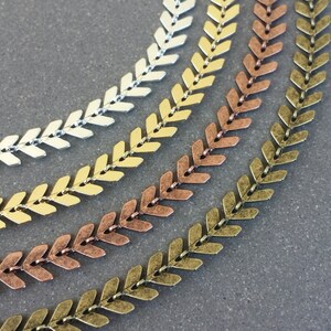 May include: Four strands of arrowhead chain in silver, gold, copper, and antique brass.