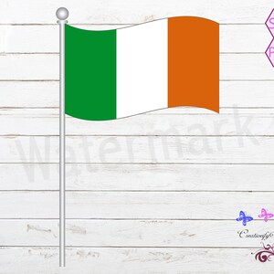 Puede incluir: Una bandera de Irlanda verde, blanca y naranja está unida a un poste plateado sobre un fondo de madera blanca.