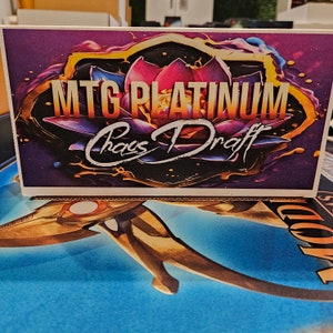 May include: A purple and gold card with a lotus flower design and the text "MTG Platinum Chaos Draft".