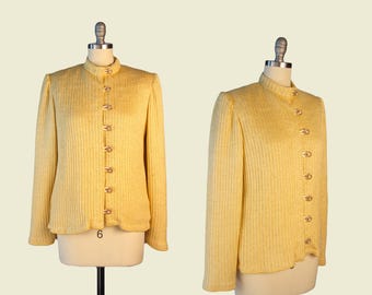 May include: A yellow knitted blazer with a high collar and button closure. The blazer has a ribbed texture and a slightly fitted silhouette.
