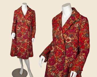 May include: A long-sleeved, knee-length coat featuring a vibrant, multi-colored floral and paisley pattern in shades of red, orange, pink, and green. The coat has a notched lapel collar, a double-breasted front closure with buttons, and a quilted texture.