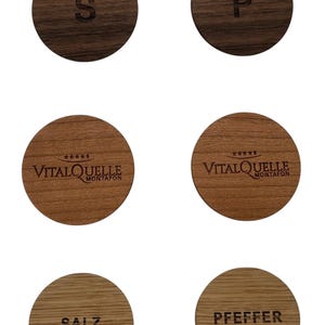 Pu&ograve; includere: Sei coperchi rotondi in legno per barattoli di spezie con testo inciso. I coperchi sono in legno marrone scuro e legno marrone chiaro. Il testo sui coperchi recita "S", "P", "VITALQUELLE MONTAFON", "VITALQUELLE MONTAFON", "SALZ" e "PFEFFER".