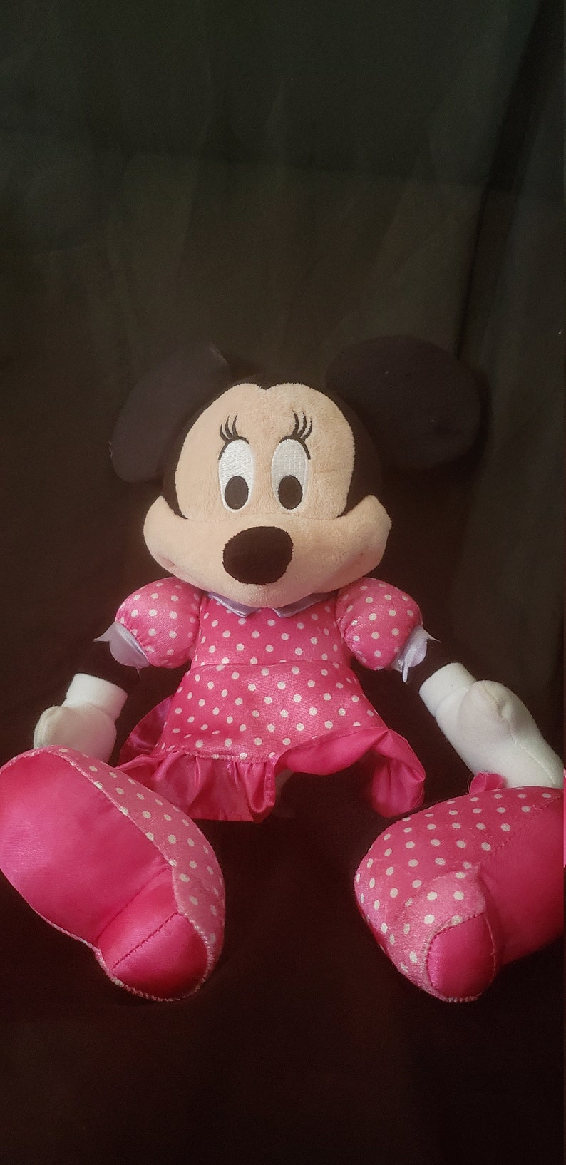 Pu&ograve; includere: Un vestito a pois rosa e bianchi con un fiocco di raso rosa. Il giocattolo di peluche &egrave; un personaggio dei cartoni animati con orecchie nere e occhi grandi.