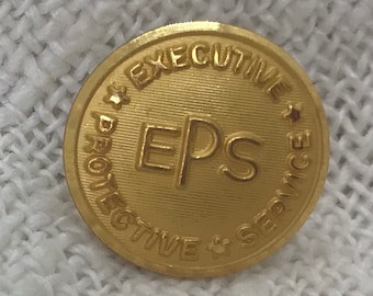 May include: Gold-colored metal pin with the text "Executive Protective Service" and the acronym "EPS" in the center.