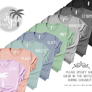 May include: A variety of t-shirt colors are displayed, including black, storm, overcast, mint, slate, breeze, peach, lilac. The text "Please specify shirt color in the notes box during checkout" is displayed below the shirts.